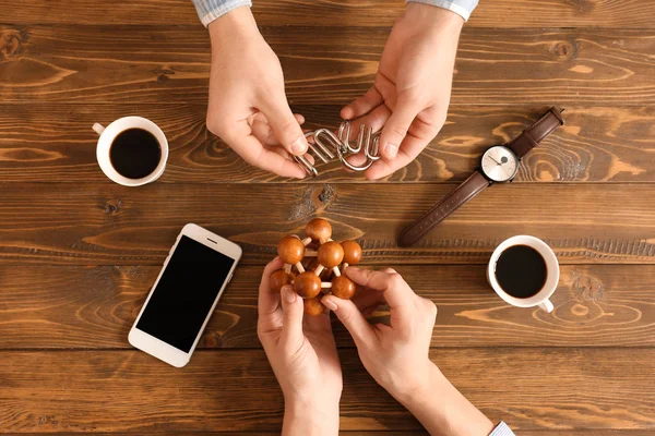 Young people with brain teasers at wooden table