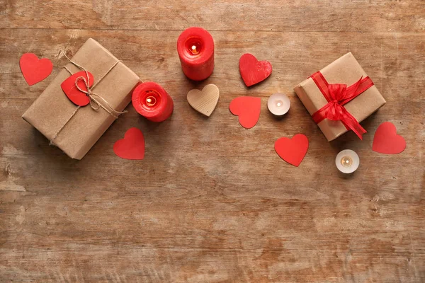 Gift boxes for Valentines Day with candles on wooden table