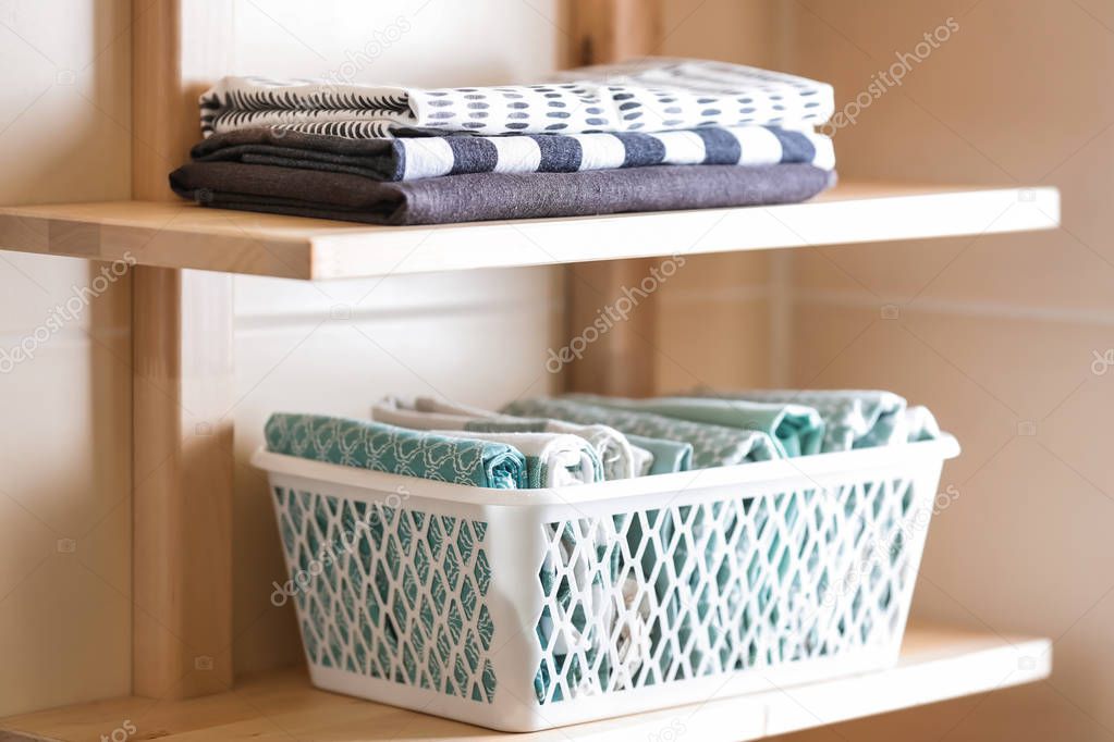 Clean kitchen towels on wooden shelves