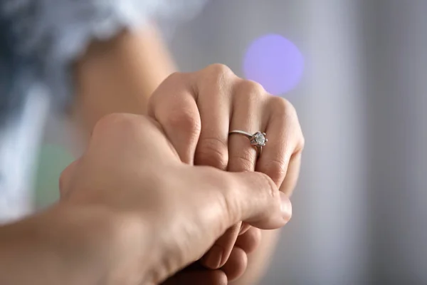 男子拿着他的未婚妻的手与订婚戒指在手指上 特写镜头 — 图库照片