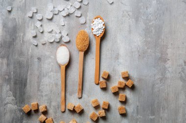 Kaşık şeker gri arka plan üzerinde farklı tür