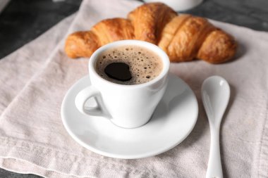 Fincan lezzetli aromatik kahve ve kruvasan masada