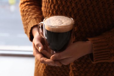 Cam fincan lezzetli aromatik kahve pencere, closeup yakınındaki kadınla