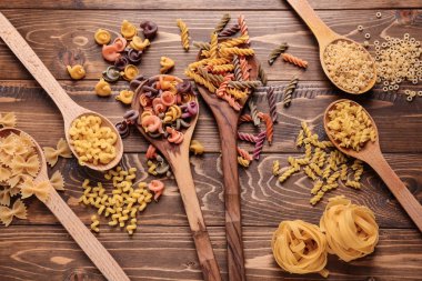 Kaşık ile farklı tip-in pişmemiş makarna üzerine ahşap masa