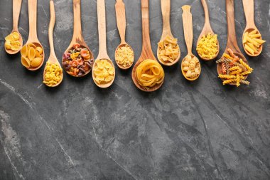 Kaşık ile farklı gri masada pişmemiş makarna