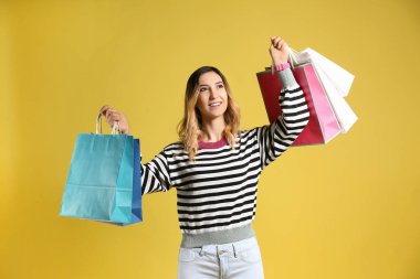 Arkaplanda alışveriş torbaları olan güzel genç bir kadın.