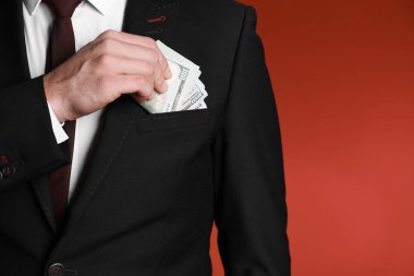Rüşvet cebine koyarak renk arka plan üzerinde iş adamı. Yolsuzluk kavramı
