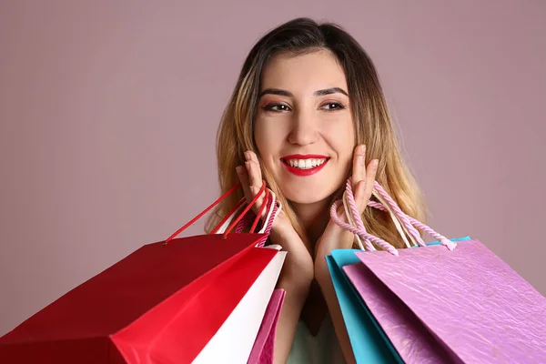 Schöne Junge Frau Mit Einkaufstaschen Auf Farbigem Hintergrund — Stockfoto
