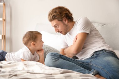 Baba ve sevimli küçük oğlu evde yatakta