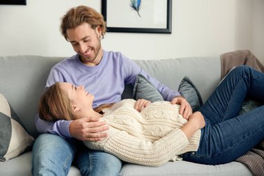 Genç hamile bir kadın kocasıyla birlikte evde.