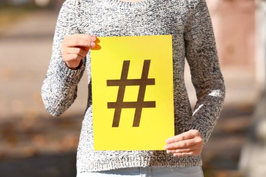 Kağıt hashtag işareti ile açık havada tutan kadın