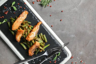 Lezzetli kızarmış balık ve yeşil fasulye gri masada arduvaz levha