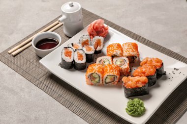 Gri masada lezzetli sushi kümesi alır