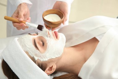 Maske yüz güzellik salonu içinde genç kadın üzerine uygulama güzellik uzmanı
