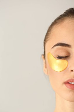 Işık arka plan üzerinde altında göz bandı olan güzel kadın