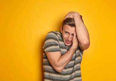 Renk arka plan üzerinde korkmuş genç adam portresi