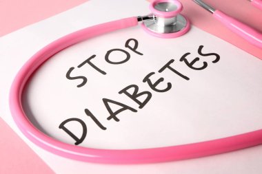 Metin durdurmak diyabet ile kağıt levha ve renk arka plan, closeup stetoskop