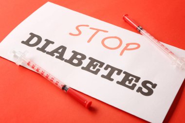 Metin durdurmak diyabet ile kağıt ve renkli arka plan üzerinde şırınga