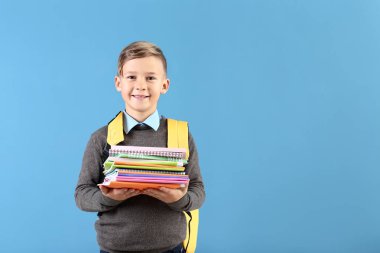 Sırt çantası ve Kırtasiye renk arka plan üzerinde şirin küçük öğrenci