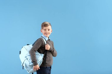 Renk arka plan üzerinde sırt çantası ile şirin küçük öğrenci