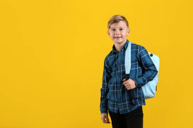 Renk arka plan üzerinde sırt çantası ile şirin küçük öğrenci