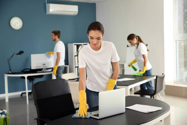 Team of janitors cleaning office