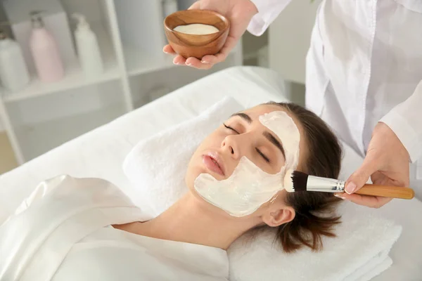 Kosmetička Použití Masky Obličej Mladé Ženy Salonu Krásy — Stock fotografie