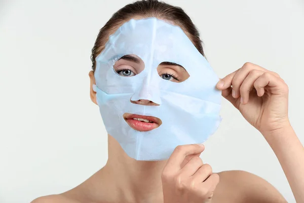 Hermosa Mujer Joven Con Mascarilla Facial Hoja Sobre Fondo Blanco — Foto de Stock