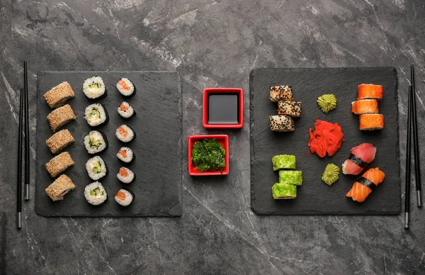 在黑暗的桌子上贴上不同的寿司盘 — 图库照片
