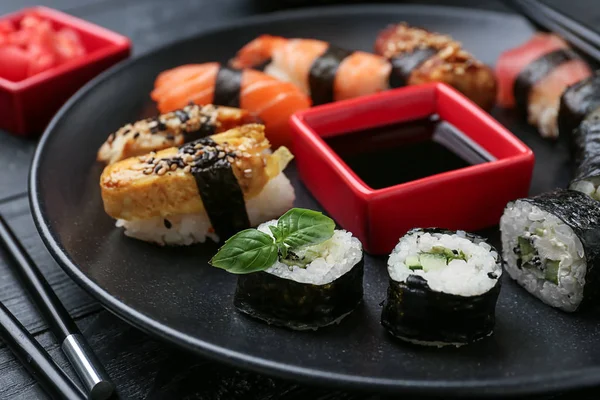 Verschiedene Leckere Sushi Mit Sauce Auf Dunklem Teller — Stockfoto