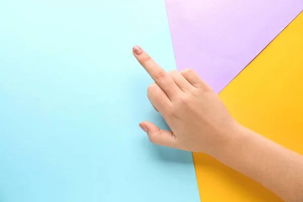 Female hand showing middle finger on colorful background
