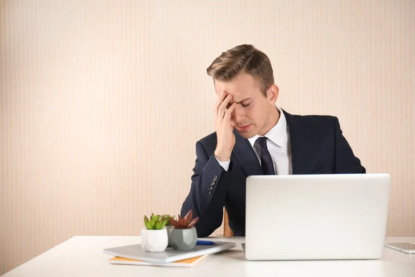 Gestresster Jungunternehmer Tisch Vor Hellem Hintergrund — Stockfoto