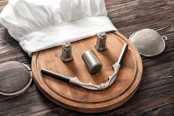 Şef şapkasını, Yönetim Kurulu ve mutfak eşyaları ahşap arka plan üzerinde kesme ile yaratıcı kompozisyon