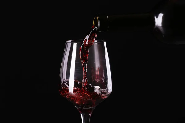 Versare Vino Rosso Dalla Bottiglia Bicchiere Fondo Scuro — Foto Stock