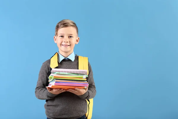 Niedlicher Kleiner Schuljunge Mit Rucksack Und Schreibwaren Auf Farbigem Hintergrund — Stockfoto
