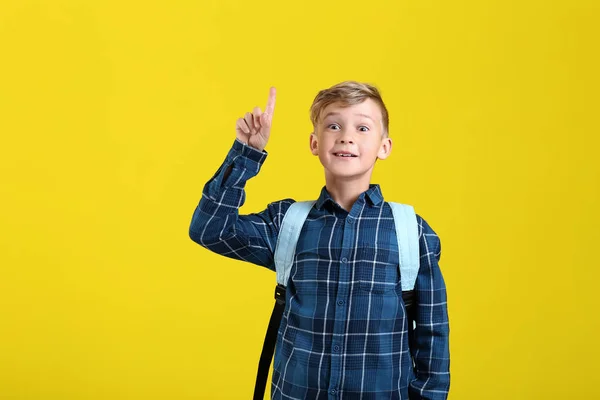 Niedlicher Kleiner Schuljunge Mit Rucksack Und Erhobenem Zeigefinger Auf Farbigem — Stockfoto