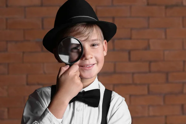 レンガの壁に虫眼鏡でかわいい小さな探偵 — ストック写真