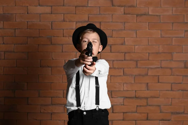 Schattige Kleine Detective Met Pistool Tegen Muur — Stockfoto