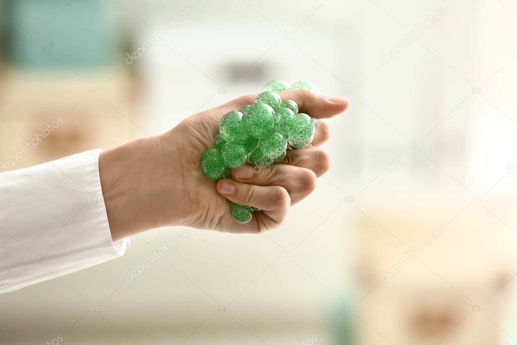 Woman squeezing stress ball, closeup