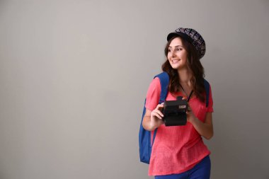 Gri arka plan üzerinde kamera ile kadın turist