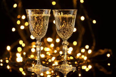 Bardak ufuk ışık karşı koyu arka plan üzerinde lezzetli şampanya