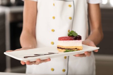 Sevimli küçük şef mutfak, closeup lezzetli tatlı ile