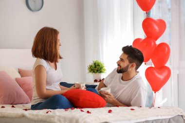 Seven genç çift evde yatakta kahve içme. Saint Valentine's Day kutlamaları