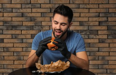 Genç adam kafede lezzetli hamburger yeme