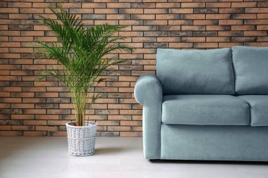 Rahat kanepe ve tuğla duvar odadaki yakınındaki houseplant