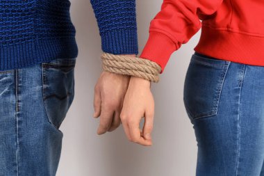 Çift ile birlikte açık renkli elleri kolları bağlı. Bağımlılık kavramı