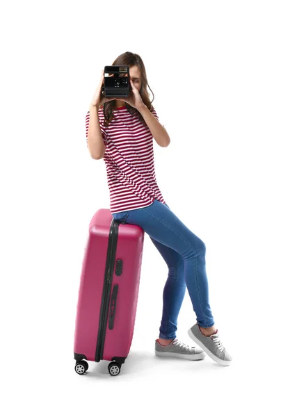 Female tourist with luggage and camera on white background