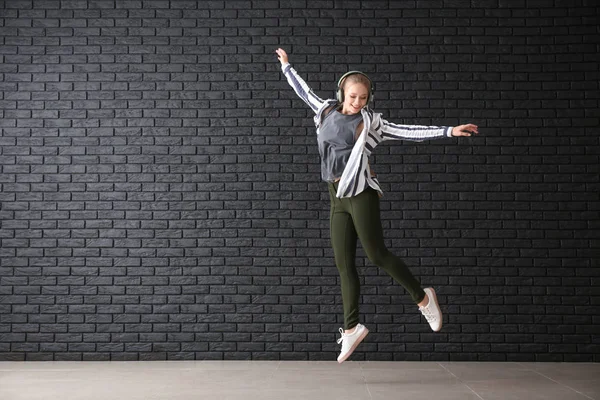 Schöne Junge Frau Tanzt Gegen Dunkle Backsteinmauer — Stockfoto