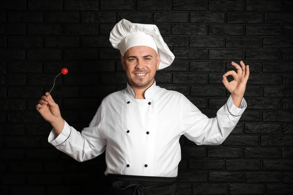 Chef Masculino Com Tomate Garfo Mostrando Gesto Contra Fundo Escuro — Fotografia de Stock