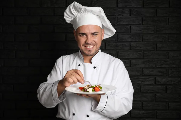 Chef Masculino Con Sabrosa Ensalada Sobre Fondo Oscuro —  Fotos de Stock